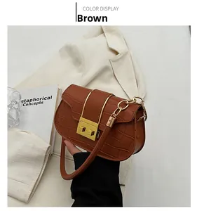 Close-up of brown crocodile pattern shoulder bag with golden metal buckle and chain