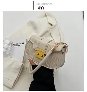 Detail of cream crocodile embossed handbag with golden metallic clasp and retro texture