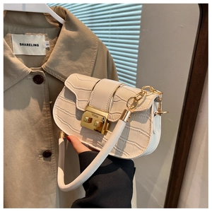Detailed view of cream-white faux crocodile leather bag with gold chain and metal lock