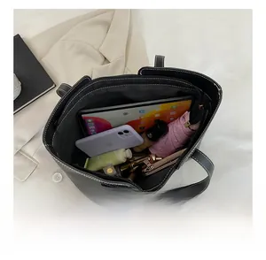 Spacious black leather tote interior showing tablet, wallet, and essentials for daily use