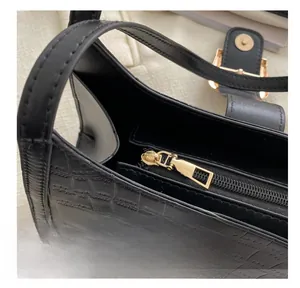Detailed macro view of black crocodile pattern leather texture and smooth golden zipper