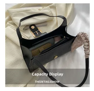 Interior view showing capacity of black crocodile pattern shoulder bag with silk scarf