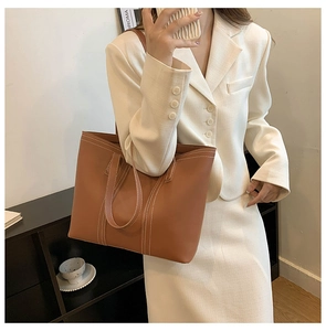 Brown vintage tote bag detail showing large capacity with white contrast stitching
