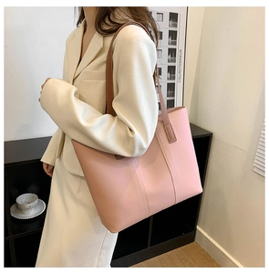Detail of pink vintage tote bag with brown straps and vertical stitching for daily commute