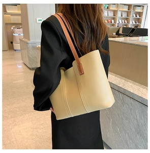Detail view of large cream PU leather tote bag with brown straps for office commute