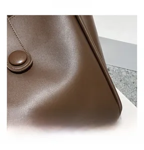 Gros plan sur le sac fourre-tout marron en similicuir avec texture grainée et coutures