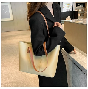 Detail of beige tote bag with brown straps and white stitching for daily commuting