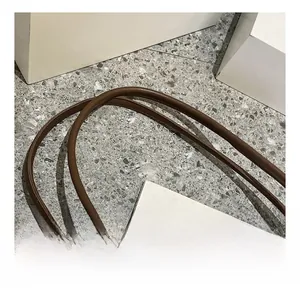 Gros plan des bandoulières rondes en cuir marron avec coutures fines du cabas