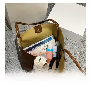 Vue de dessus du grand compartiment intérieur du sac cabas en cuir marron avec fermeture