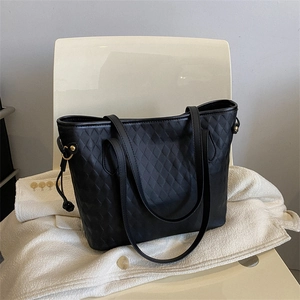 Large black quilted tote bag with diamond pattern and leather shoulder straps for commuting