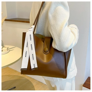 Détail d'un sac cabas marron avec ruban tendance moderne et fermoir magnétique chic