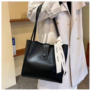 Vue détaillée d'un sac cabas en similicuir noir avec ruban de mode et fermoir aimanté
