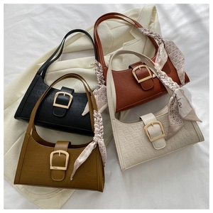 Detail of four faux-crocodile leather crescent bags with silk scarves and gold buckles