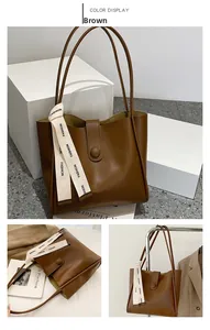 Détail d'un grand sac cabas marron avec ruban tendance et fermeture à bouton en gros plan