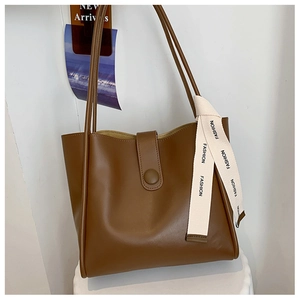 Détail du sac cabas marron en similicuir avec bouton magnétique et ruban décoratif