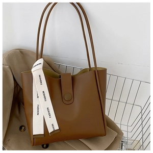 Détail d'un sac cabas marron avec sangles et ruban mode dans un chariot d'achat