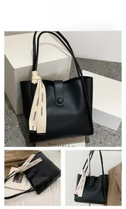 Détail du sac cabas en cuir PU noir mat avec un ruban beige imprimé 'FASHION' élégant