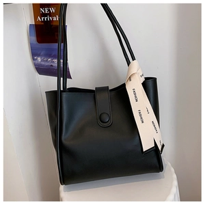 Détail du cabas en cuir noir avec ruban décoratif FASHION et boucle magnétique élégante