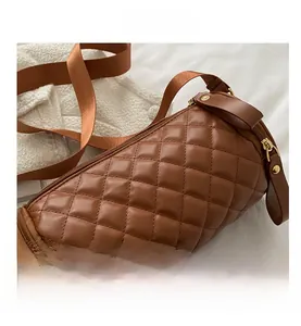 Vue détaillée du sac cylindre marron avec matelassage en losange et zip doré