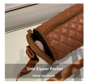 Détail du sac cylindrique matelassé marron avec poche zippée latérale et bandoulière