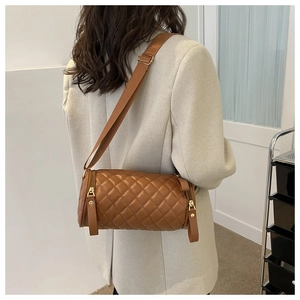 Vue de dos d'un mannequin portant un sac cylindrique matelassé marron à bandoulière