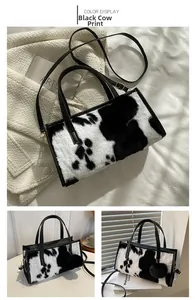 Detail of faux fur cow print handbag with black leather handle and plush charm detail