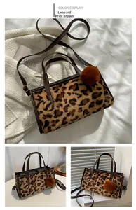 Detail view of leopard print tote bag with plush texture and decorative pom-pom charm