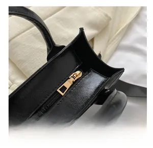 Détail du zip métallique doré fluide sur le sac à main en cuir verni noir