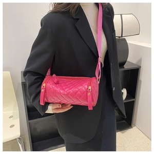 Détail du sac cylindre matelassé rose vif avec large bandoulière en textile