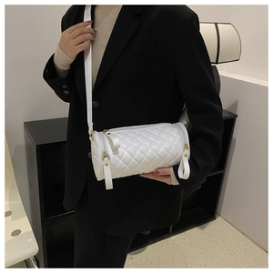 Détail du sac cylindre blanc matelassé en cuir brillant avec fermeture éclair dorée