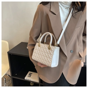 Detailed view of quilted white crossbody bag with gold hardware and chain strap