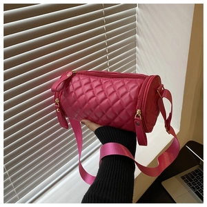 Détail du sac cylindre rose fuchsia matelassé avec finitions dorées élégantes