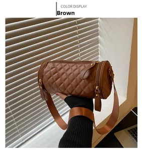 Vue détaillée du sac cylindrique matelassé marron avec large bandoulière en textile