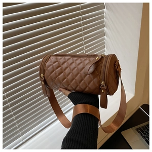 Détail du sac cylindrique matelassé marron avec large bandoulière en nylon de style urbain