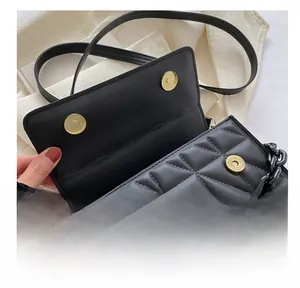 Detail of black quilted PU leather bag featuring double gold magnetic closures and chain strap