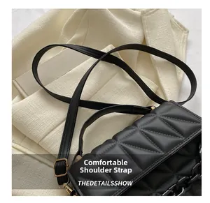 Detail of black quilted shoulder bag featuring comfortable adjustable strap and bold chain
