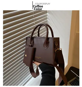 Détail du cabas en similicuir marron avec porte-monnaie assorti et bandoulière large