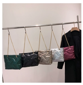 Detailansicht gesteppter Daunentaschen in verschiedenen Farben mit goldener Kette