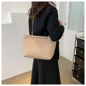 Close-up of beige crocodile pattern tote bag featuring a metal chain leather shoulder strap