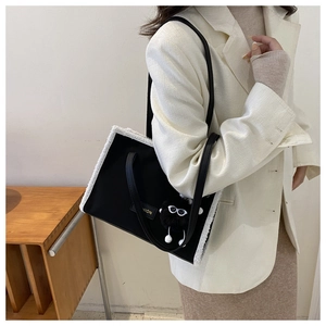 Détail du sac cabas noir avec bordure en peluche blanche et plaque dorée FASHION