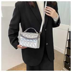Detail of silver geometric quilted crossbody bag with grey matte thick chain accessory