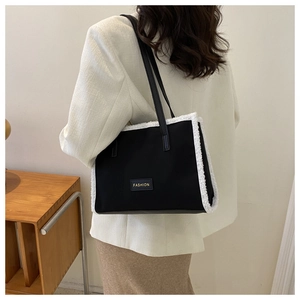 Détail du grand sac cabas noir avec bordure en fausse fourrure blanche et patch FASHION