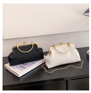 Details von plissierten Abendtaschen in Schwarz und Weiß mit goldenen Metallgriffen