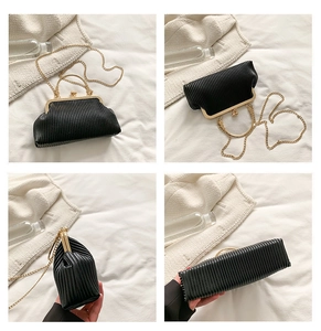 Detailansicht der schwarzen Falten-Clutch mit Goldrahmen und Vintage-Perlenverschluss