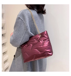 Detailansicht der glänzend violetten Stepptasche mit goldenen Kettenriemen und gepolsterter Optik