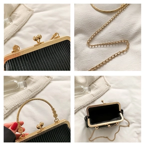 Makroaufnahme der schwarzen Falten-Clutch mit goldenem Verschluss und Metallringgriff-Details