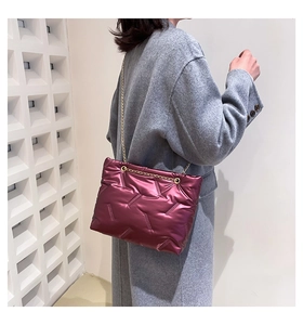 Burgunderrote Stepptasche mit Kette an Model in grauem Wollmantel zur Größenreferenz