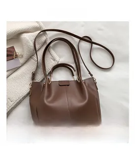 Detail view of brown vintage bucket bag featuring vertical stitching and metal buckles