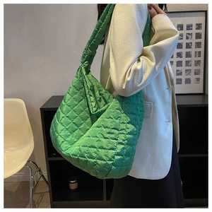 Macro shot of vibrant green quilted puffer bag texture and high-quality stitch detail