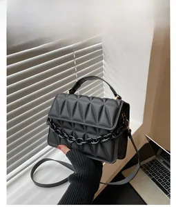 Close-up of black quilted shoulder bag with gold hardware and elegant chain detail